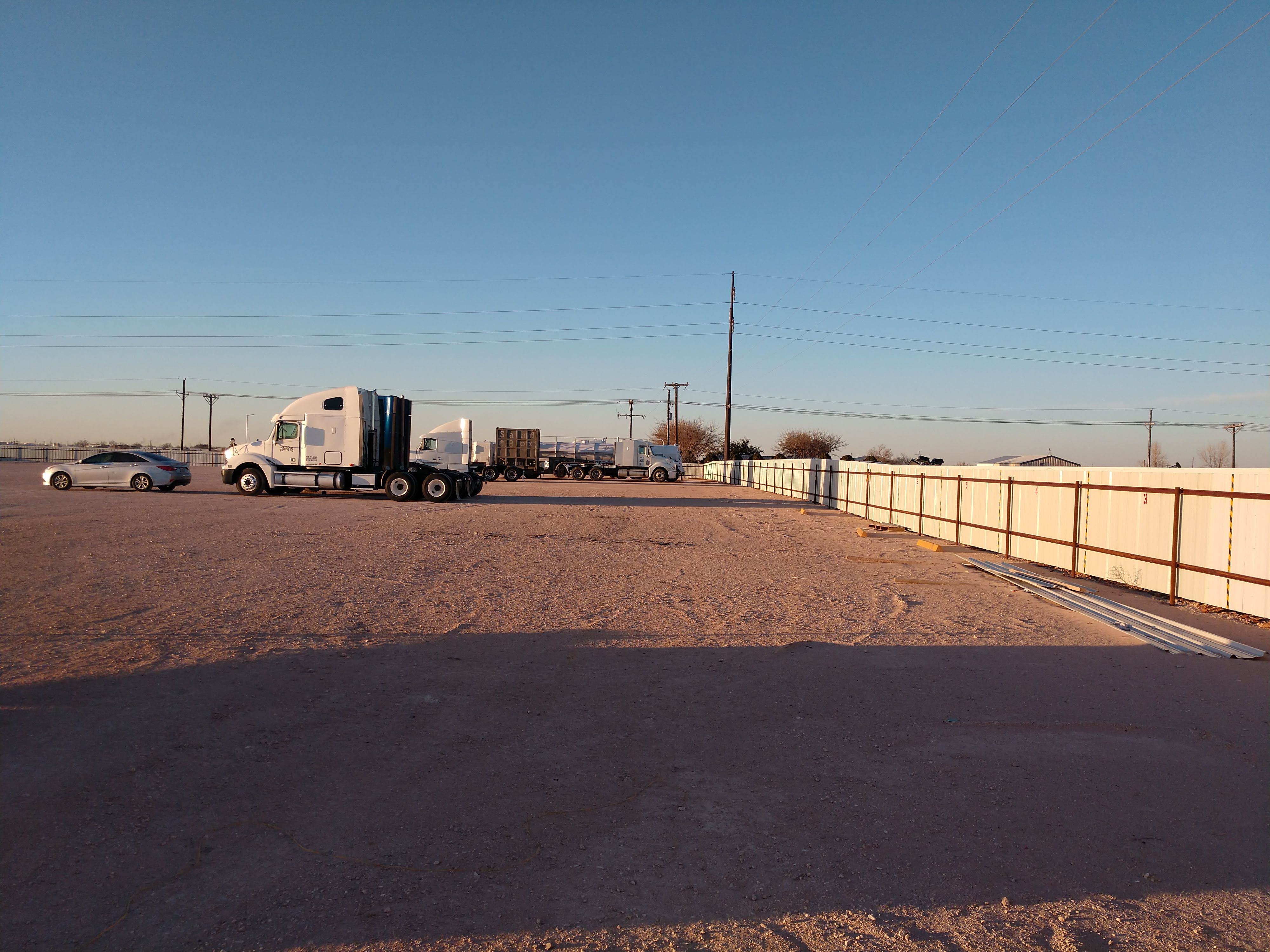 CADD Truck Parking lot at sunset with trucks and fencing